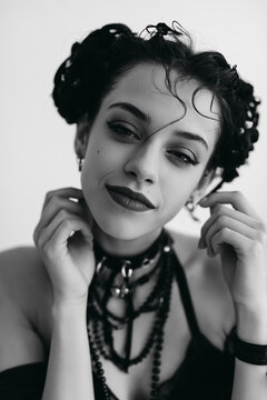 Portrait of woman with dramatic makeup and layered necklaces in black and white close up