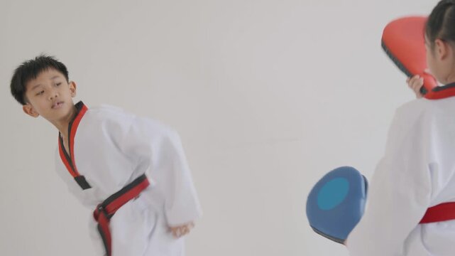Children practicing martial arts skills in a training session in a dojo