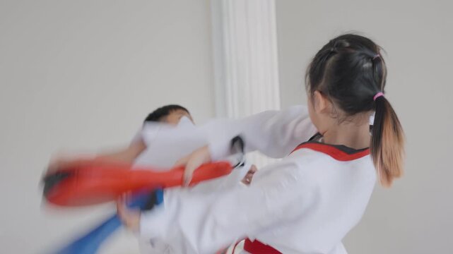 Children practicing martial arts skills in a training session in a dojo