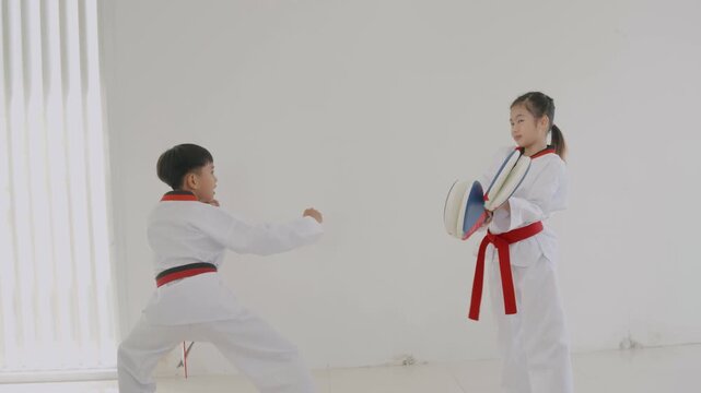 Children practicing martial arts skills in a training session in a dojo