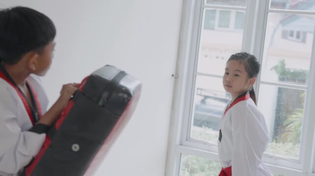 Young students practice martial arts in a training session with focus on kicks and moves during a class in the dojo