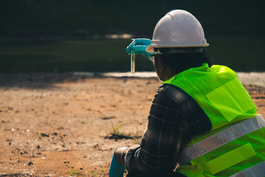 Environmental researchers collecting river water samples for scientific pollution analysis.
