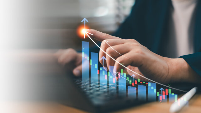 Investor pointing at virtual financial stock market growth chart with candlestick bar graph for business return on investment ROI, economic wealth analytics and successful trading strategy concept