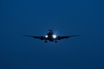 Commercial Passenger Airplane Landing at Dusk with Landing Lights On   Lądowanie komercyjnego samolotu pasażerskiego o zmierzchu z włączonymi światłami lądowania © Adrian White