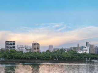 Obraz premium 夕暮れ時の水辺の街並みと広がる夕雲