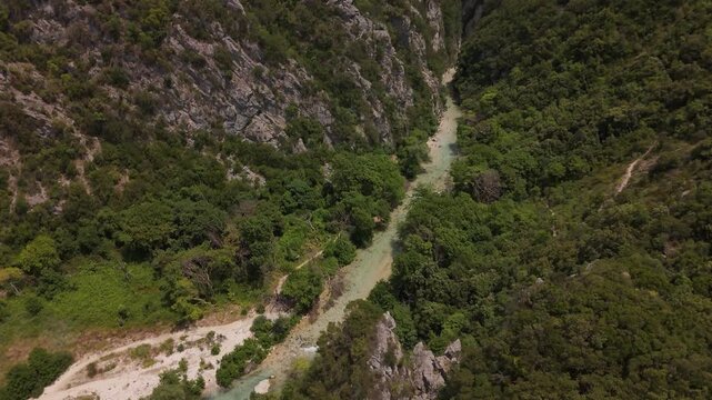 Aerial view of Acheron river flowing through a deep green rocky canyon, Epirus, Greece (4K)