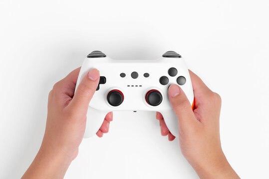 Female hands holding a white wireless gamepad on white background, top view