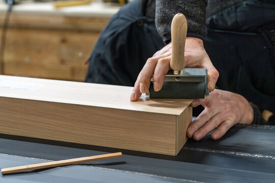 Craftsman applying finish stamp on a wood plank