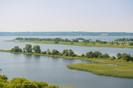 Natural scene with tranquil river meanders through green field and open marsh