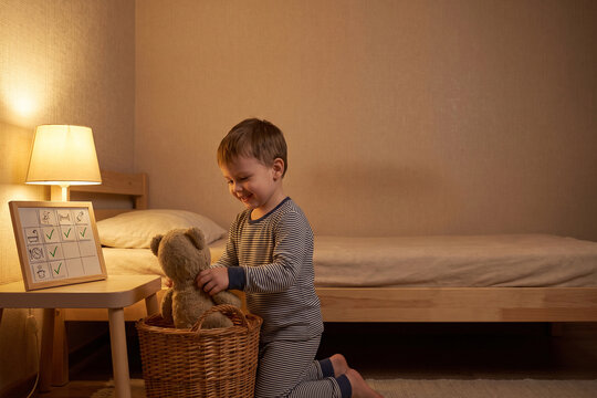 Young Child Putting Teddy Bear Away During Bedtime Routine for Independent Life Skills