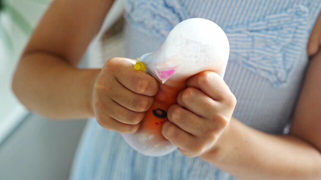 Hands squeeze a soft squishy stress relief toy during sensory play. Tactile interaction promotes relaxation, emotional regulation and stress reduction.