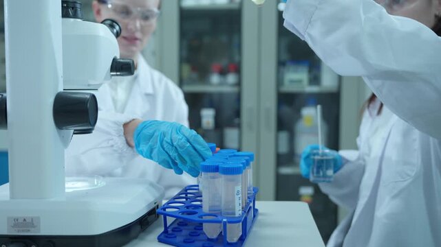 Scientists collaborating on medical research and development with test tubes and microscope in a laboratory