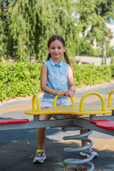Obraz premium Little cute girl in a sunlit park filled with laughter and playful adventures