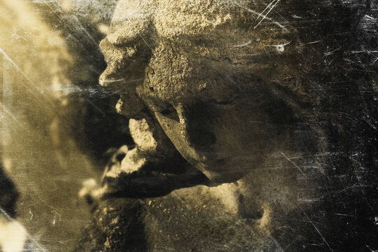 Vintage style image of a weathered stone angel illuminated by a heavenly beam of light. Symbol of remembrance, eternal peace and spiritual comfort.
