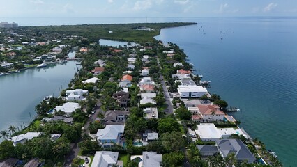 Aerial view of a coastal residential neighborhood beside mangroves with sailboats anchored in Biscayne Bay, Key Biscayne, Florida © Marisol