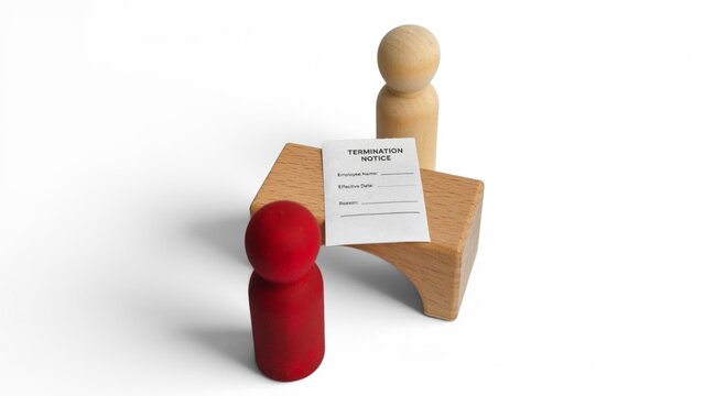 Employment layoff and human resources crisis concept with a wooden peg doll leaving after receiving a termination notice.
