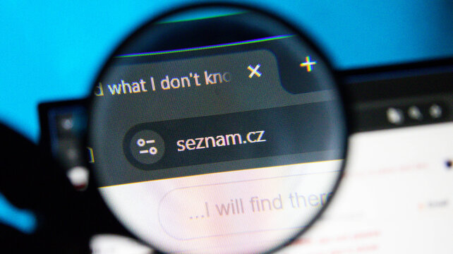 Magnifying glass over web browser showing 'seznam.cz' and search bar on blue background