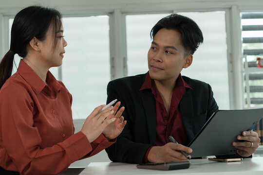 Business Colleagues Discussing Clipboard Document at Office Desk