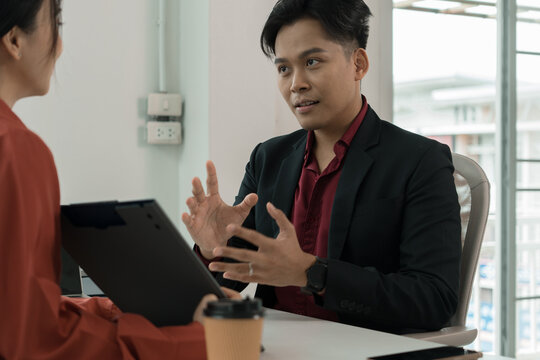 Close-Up of Business Colleagues Discussing Charts at Office Desk
