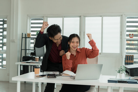 Business Team Cheering and Celebrating Success at Laptop in Office