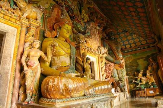 Traditional colorful Buddha statues and ancient murals inside Wewurukannala Vihara, Sri Lanka.