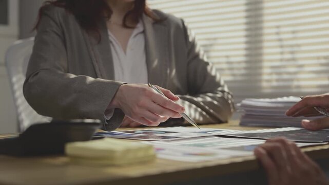 Business woman gesturing while explaining project details during a meeting in the office with a male colleague