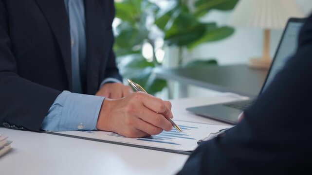 Business professionals analyzing financial charts and discussing marketing strategy in a modern office meeting