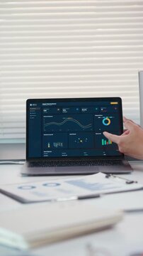Business professionals analyzing data dashboard on laptop screen during office meeting and strategic planning session