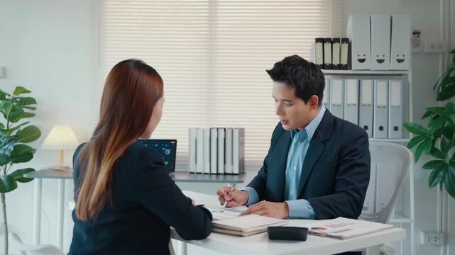 Asian business people meeting, discussing financial data analysis and company strategy in a modern office environment