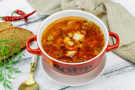 Meat solyanka soup with sausages, olives and vegetables served on table. Traditional bowl