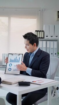 Confident businessman presenting financial data with charts and graphs during a corporate meeting in a modern office