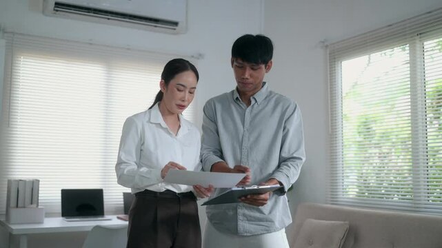 Business colleagues reviewing contract documents and signing an agreement in a modern office