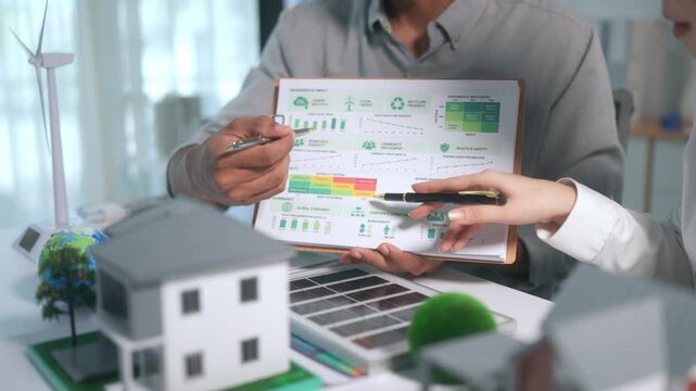Renewable energy engineers planning sustainable community with wind turbines and solar panels