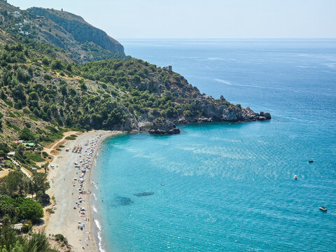 Stunning turquoise sea cove with cliffs and sandy beach wild nature Costa del Sol Nerja Spain