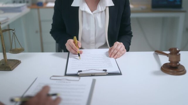 Lawyer explaining contract terms and pointing where to sign the legal document in the office