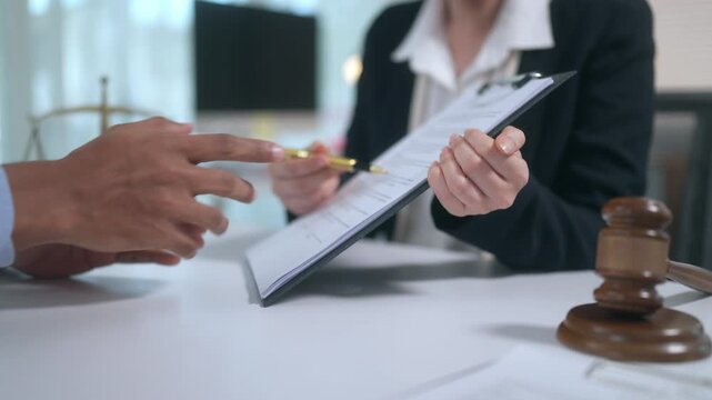 Lawyer explaining contract terms and legal document clauses to a client before signing at the law firm office