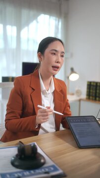 Professional lawyer explaining digital contract on tablet to a client during a consultation at the office