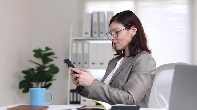 Frowning, the businesswoman slams her phone as a slow connection or faulty app frustrates her in the office