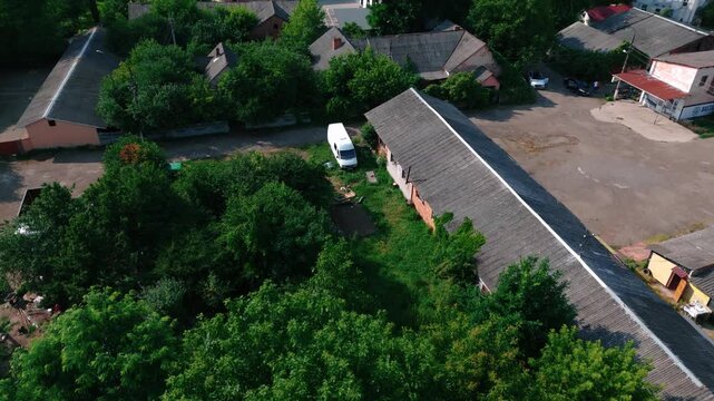 Low drone flyover industrial buildings and trees
