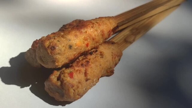 Authentic Balinese sate lilit, a traditional Indonesian satay made from seasoned minced meat wrapped around skewers and grilled to perfection.
