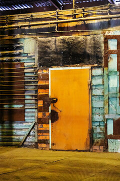 closed orange steel door in old factory workshop