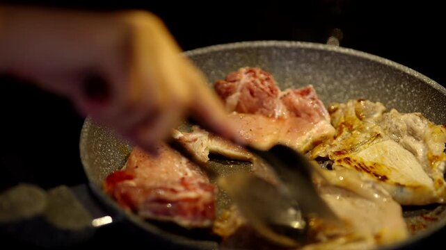 Flipping Juicy Meat Steaks With Tongs. Frying Pork Chops. Cooking Dinner Meal 