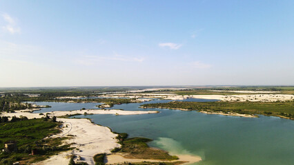 Obraz premium Aerial view of sand dunes and lakes with turquoise water reflecting a clear blue sky, a tranquil nature landscape
