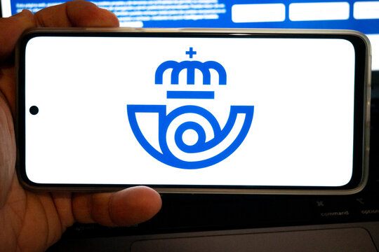 Hand holding smartphone displaying correos postal service logo