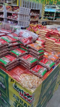 ITABIRA, MINAS GERAIS, BRAZIL - JULY, 2026: Traditional Festa Junina product display at a wholesale supermarket, featuring stacks of popcorn packages, corn kernels, peanuts, and winter festival ingred