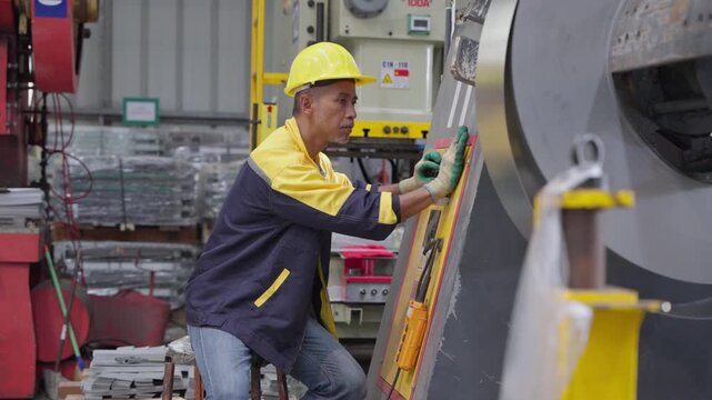 Skilled worker managing heavy machinery in a production environment while wearing protective gear and utilizing safety equipment