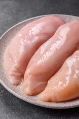 Fototapeta premium Fresh raw chicken fillet with salt and spices for home cooking. Raw chicken fillet