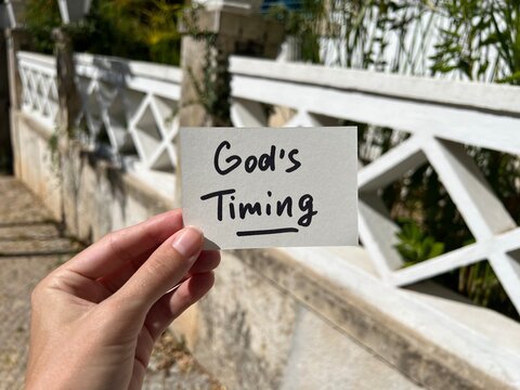 God's timing - hand with christian text outdoors, biblical faith and trust Lord concept