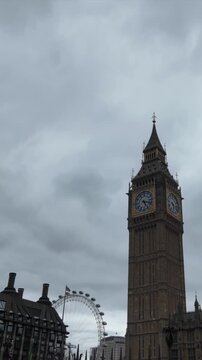 Famous big ben clock tower and london eye landmark under a dramatic cloudy sky, an iconic view of the capital city of the united kingdom, representing english culture