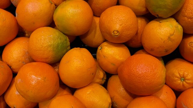 Fresh, clean, high-quality Sunkist oranges. A pile of ripe Sunkist oranges.